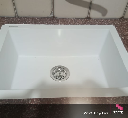 כיור מותקן על משטח שיש במטבח